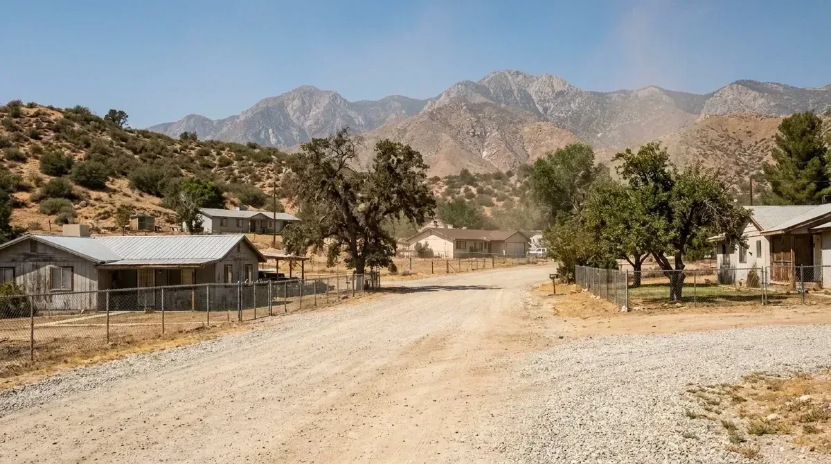 A road of older ranch houses on larger parcels, open land and the foothills behind - Emergency plumbing in Mentone
